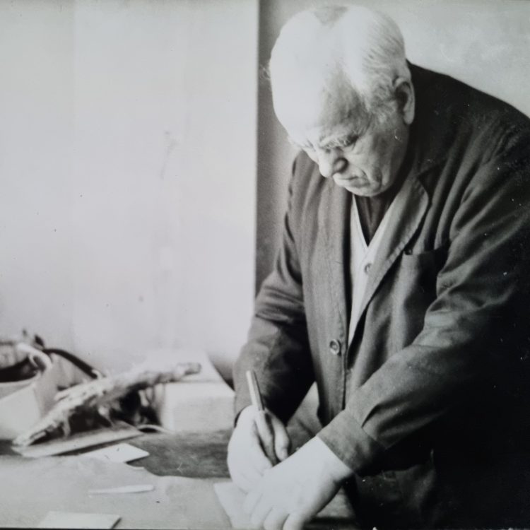 Zdjęcie przedstawia Władysława Kłodę przy pracy rymarskiej w swojej pracowni przy ulicy Międzyborskiej